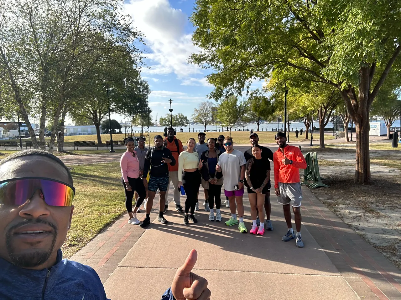 TNDO Run Club group on a tree-lined path in Norfolk, with a selfie up front