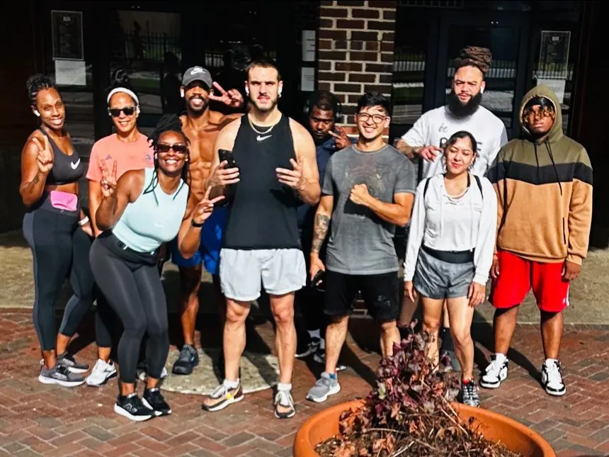TNDO Run Club members smile together on a brick plaza in downtown Norfolk