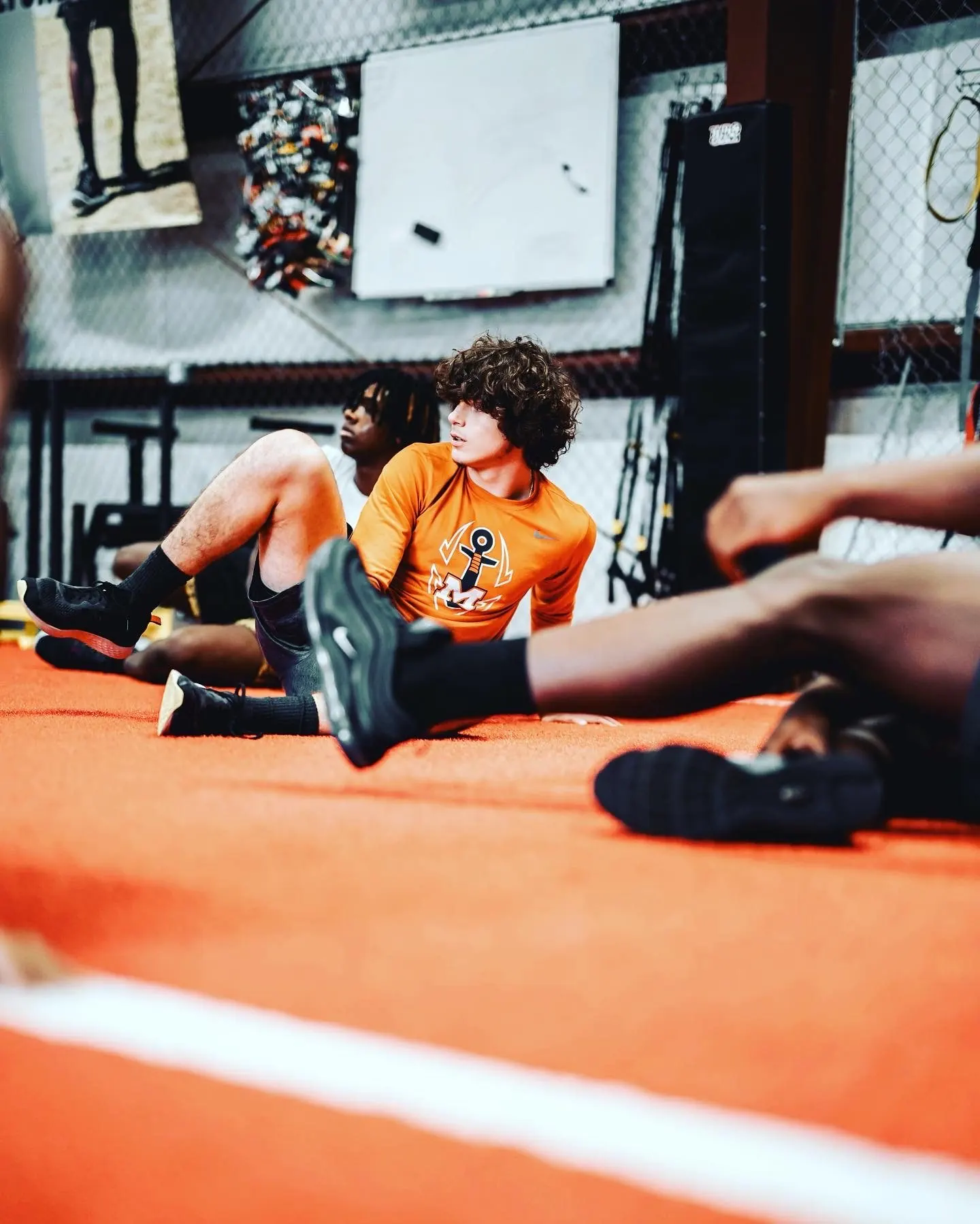 Young athletes stretch on the turf during a TNDO training session